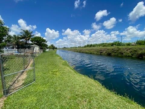 25931 Southwest 130th Avenue Homestead, FL 33032 - Photo 9 of 44 a view of a lake with a house in the background