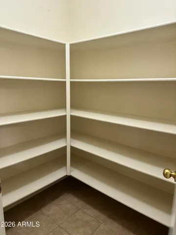 a view of walk in closet with empty racks