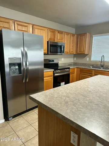 a kitchen with stainless steel appliances granite countertop a refrigerator a sink a stove a microwave and island