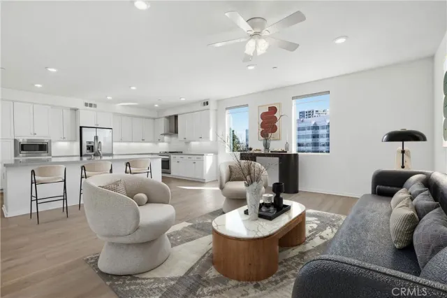 a living room with furniture kitchen view and a chandelier