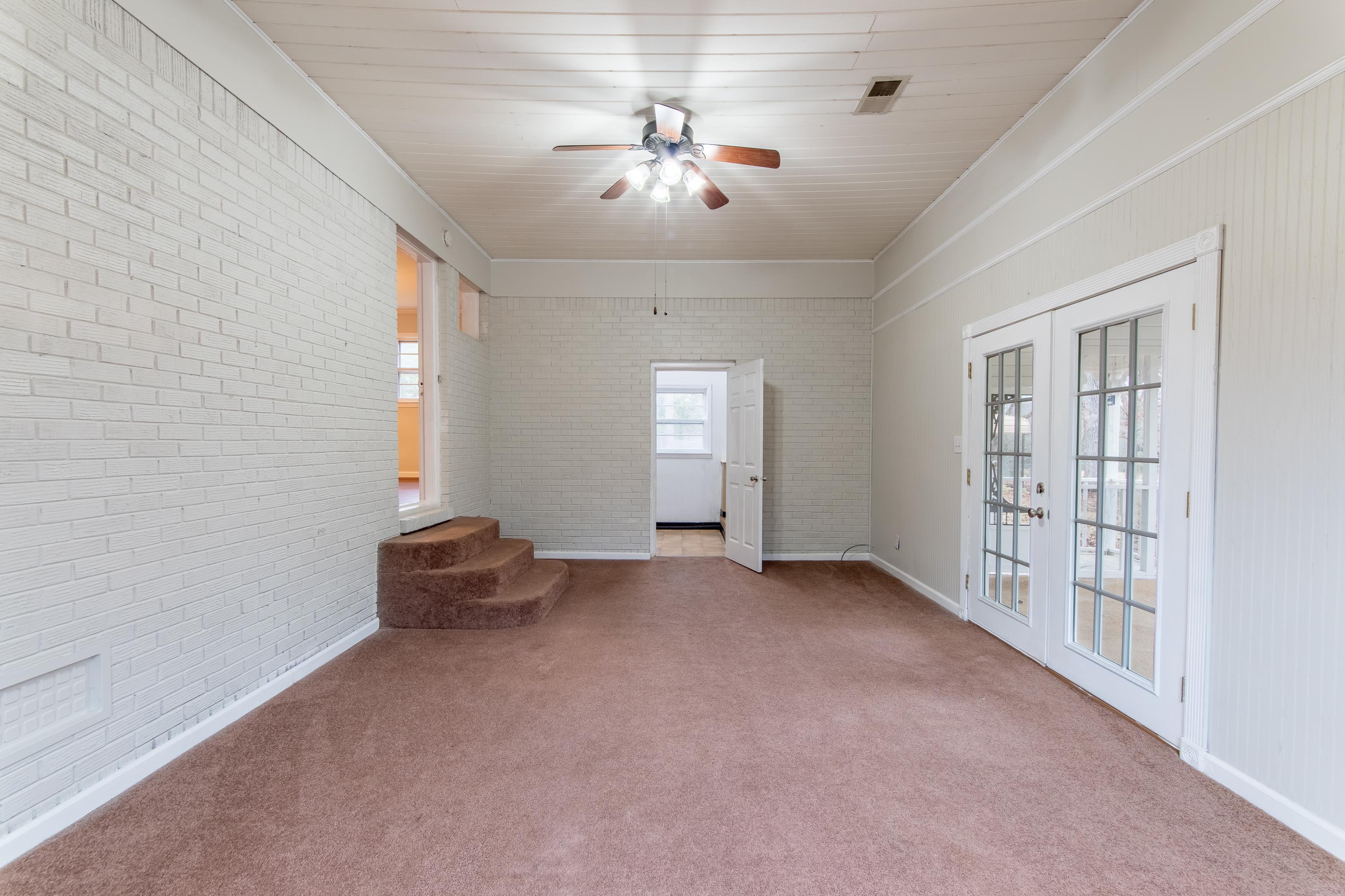 4155 Clifton Road Savannah, TN 38372 - Photo 12 of 40 Unfurnished room featuring brick wall, carpet flooring, ceiling fan, and french doors