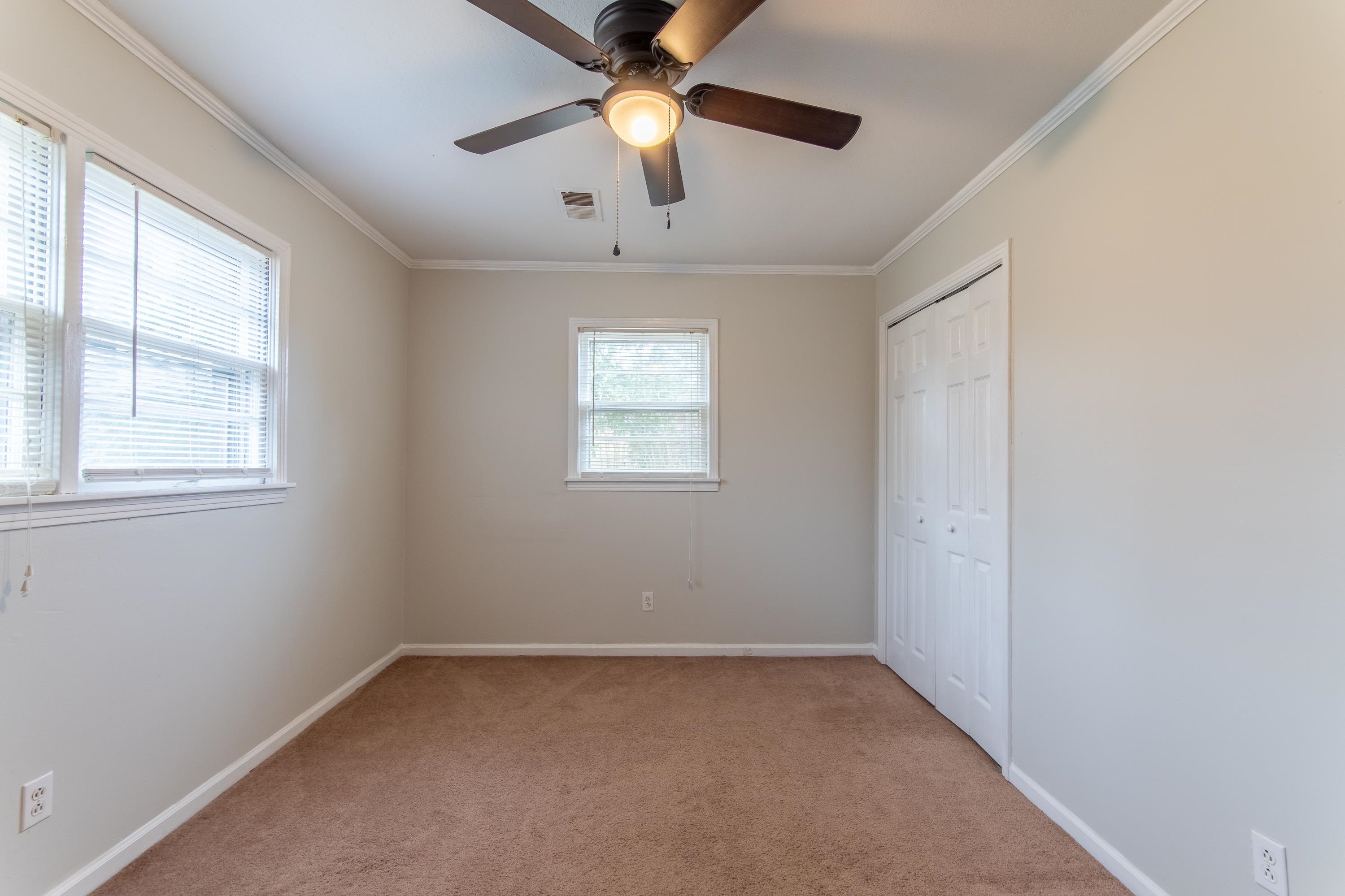 4155 Clifton Road Savannah, TN 38372 - Photo 17 of 40 Unfurnished bedroom with ceiling fan, a closet, ornamental molding, and light carpet