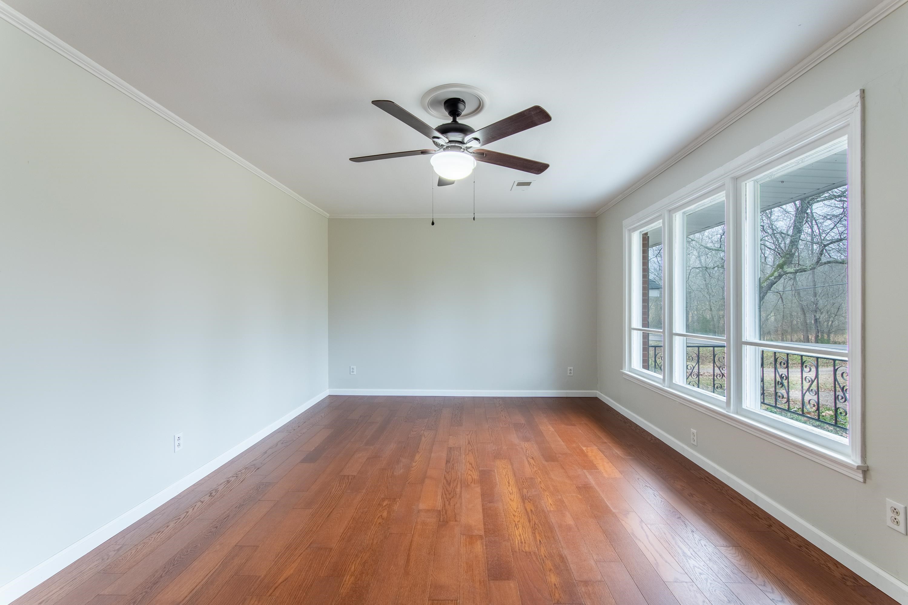 4155 Clifton Road Savannah, TN 38372 - Photo 5 of 40 Spare room with crown molding, a healthy amount of sunlight, and wood-type flooring