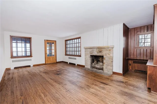 wooden floor fireplace and windows in an empty room