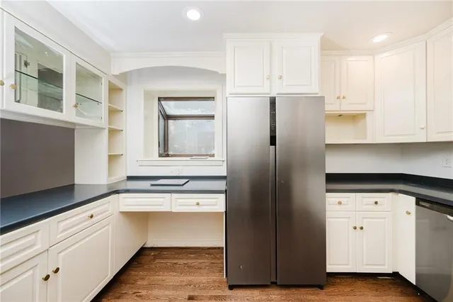 a kitchen with granite countertop white cabinets and stainless steel appliances