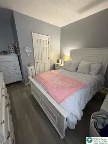 a bed sitting in a bedroom and chair with wooden floor