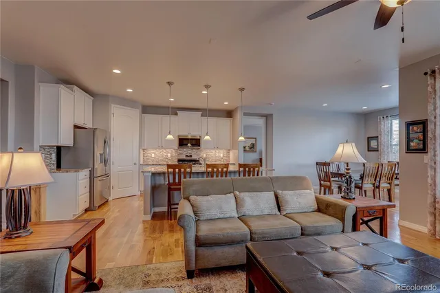 a living room with furniture and a dining table with kitchen view