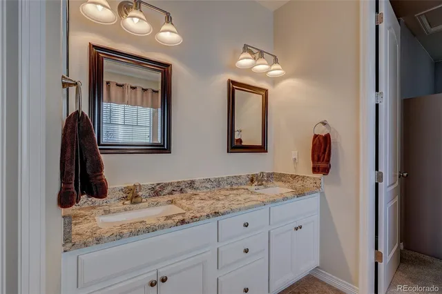 a bathroom with a granite countertop sink and a mirror