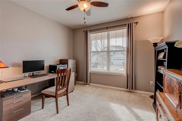 a view of a workspace with furniture and a window