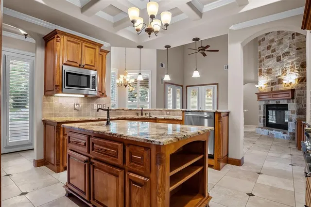 a kitchen with kitchen island granite countertop a stove oven and sink