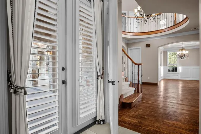 a very nice looking room with wooden floor and a chandelier
