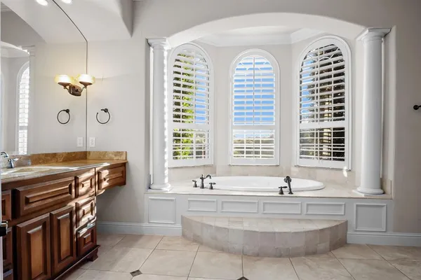 a spacious bathroom with a tub a sink and a window