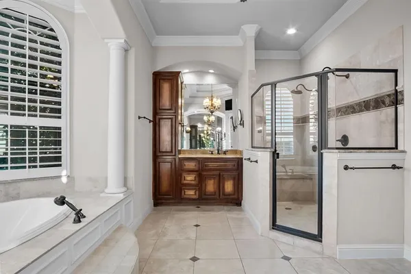 a bathroom with a tub shower sink and mirror