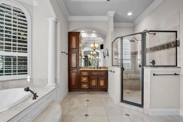 a bathroom with a tub shower sink and mirror