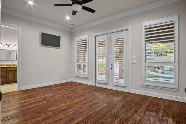 a view of an empty room with a window and wooden floor