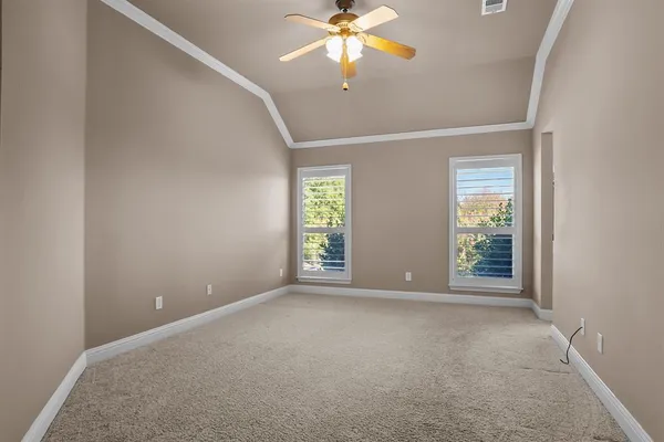 an empty room with windows and fan