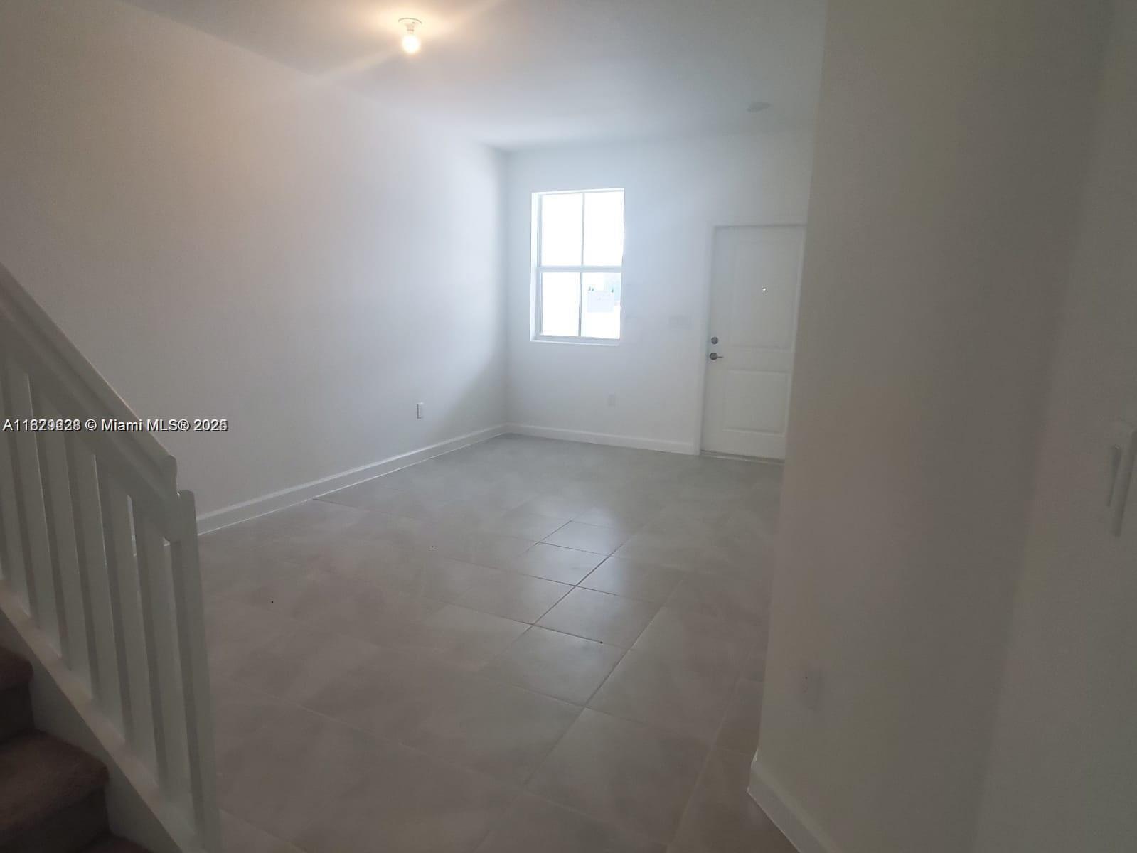 2602 Southeast 11th Street, Unit 2602 Homestead, FL 33035 - Photo 3 of 22 an empty room that has a window in it