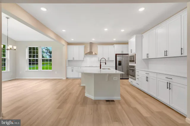 a large kitchen with kitchen island a sink a center island stainless steel appliances and a cabinets