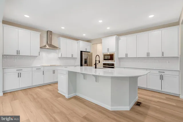 a kitchen with stainless steel appliances granite countertop a white cabinets a sink a stove a refrigerator and white cabinets