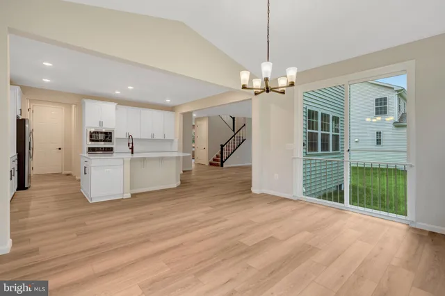 a kitchen with granite countertop white cabinets and refrigerator