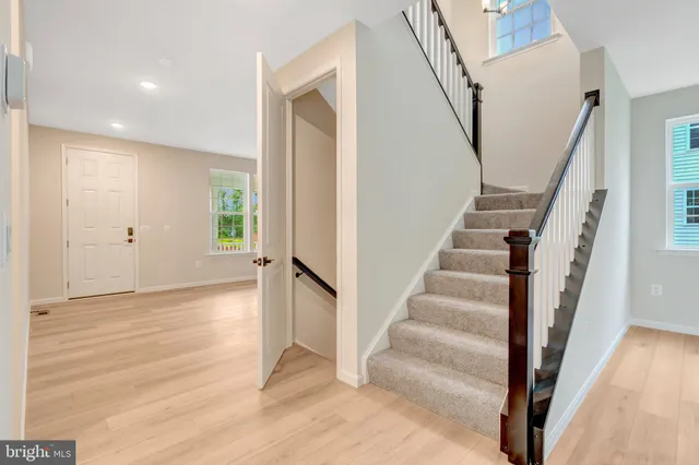 a view of a hallway with wooden floor and entryway