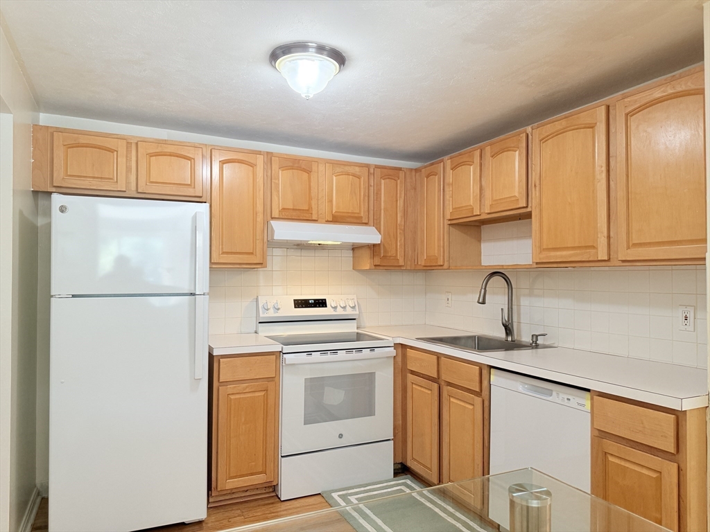 388 Great Road, Unit A1 Acton, MA 01720 - Photo 14 of 18 a kitchen with stainless steel appliances a refrigerator sink and cabinets