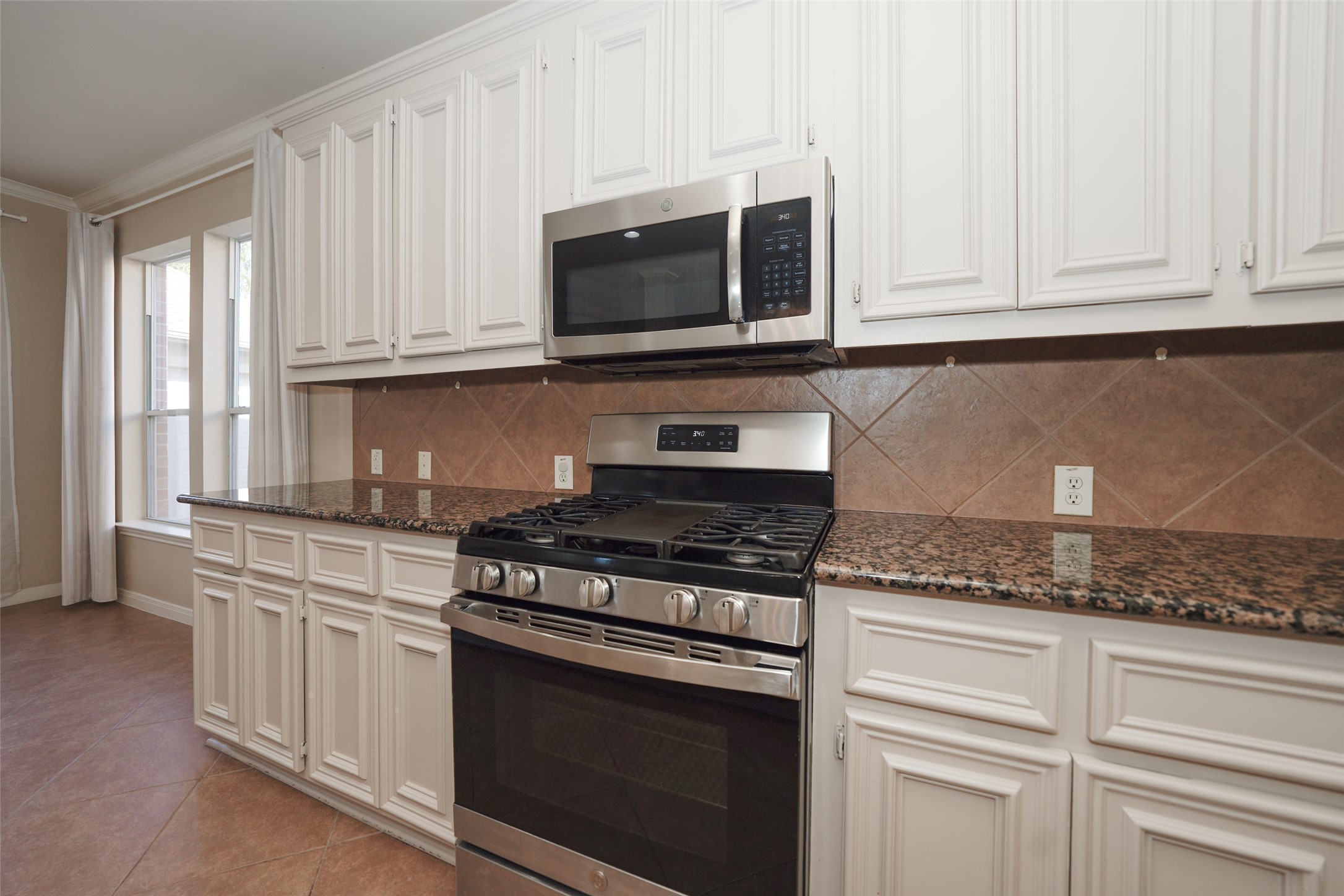 4415 Eden Point Lane Katy, TX 77494 - Photo 5 of 13 a kitchen with granite countertop white cabinets and appliances