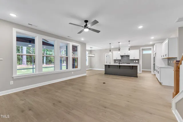 a kitchen with kitchen island a sink stainless steel appliances and windows