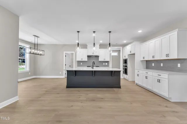 a kitchen with granite countertop white cabinets and a stove
