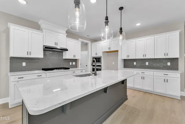 a kitchen with granite countertop white cabinets and stainless steel appliances