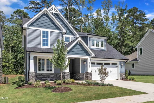 a front view of a house with a yard garden and outdoor seating