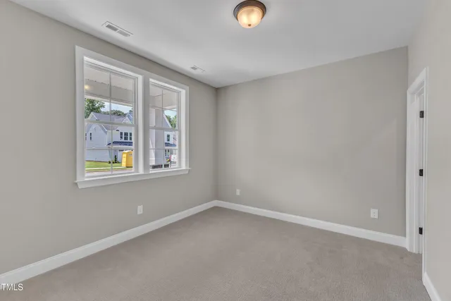 an empty room with windows and fireplace