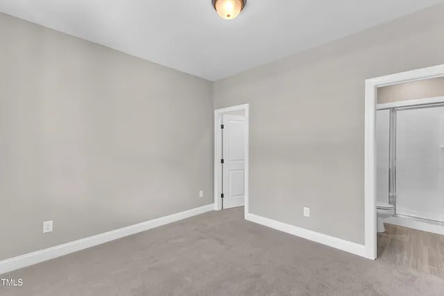 a view of an empty room with a fireplace and a window