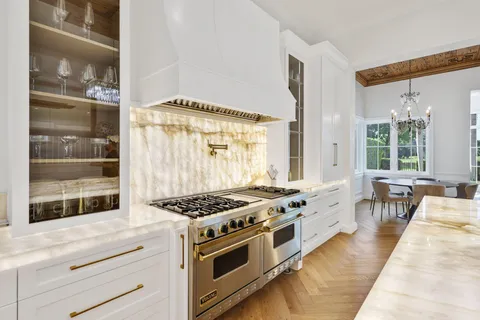 a kitchen with stainless steel appliances a stove a table and chairs