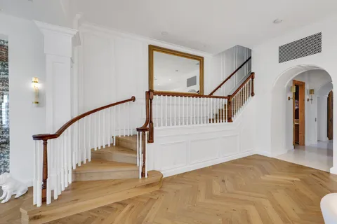 a view of staircase with white walls and a painting on the wall