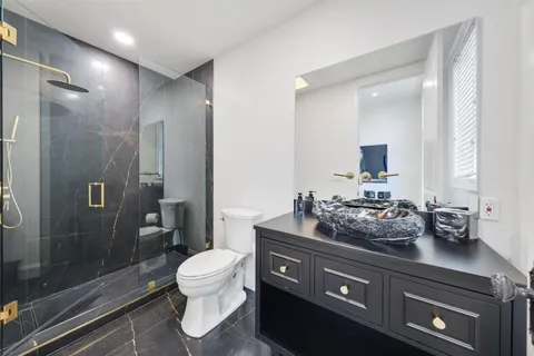 a bathroom with a toilet a sink and glass door