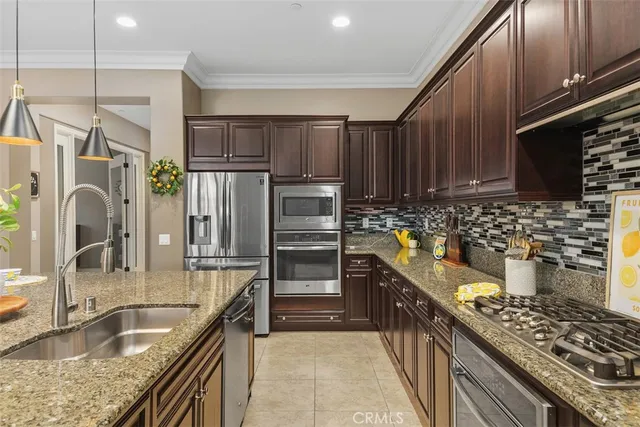 a kitchen with granite countertop a table chairs stove and refrigerator