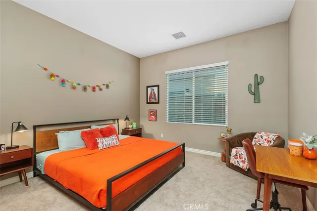 a spacious bedroom with a bed a large window and a chandelier