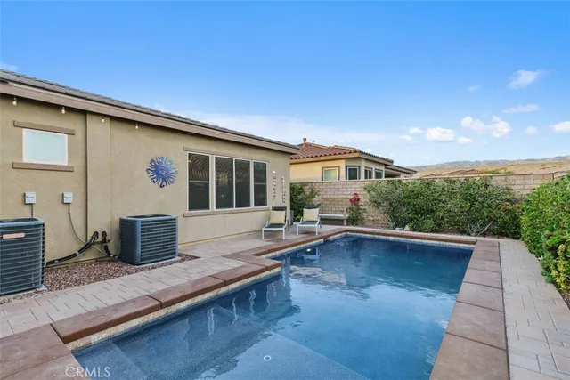 a view of a patio with couches table and chairs under an umbrella with a barbeque