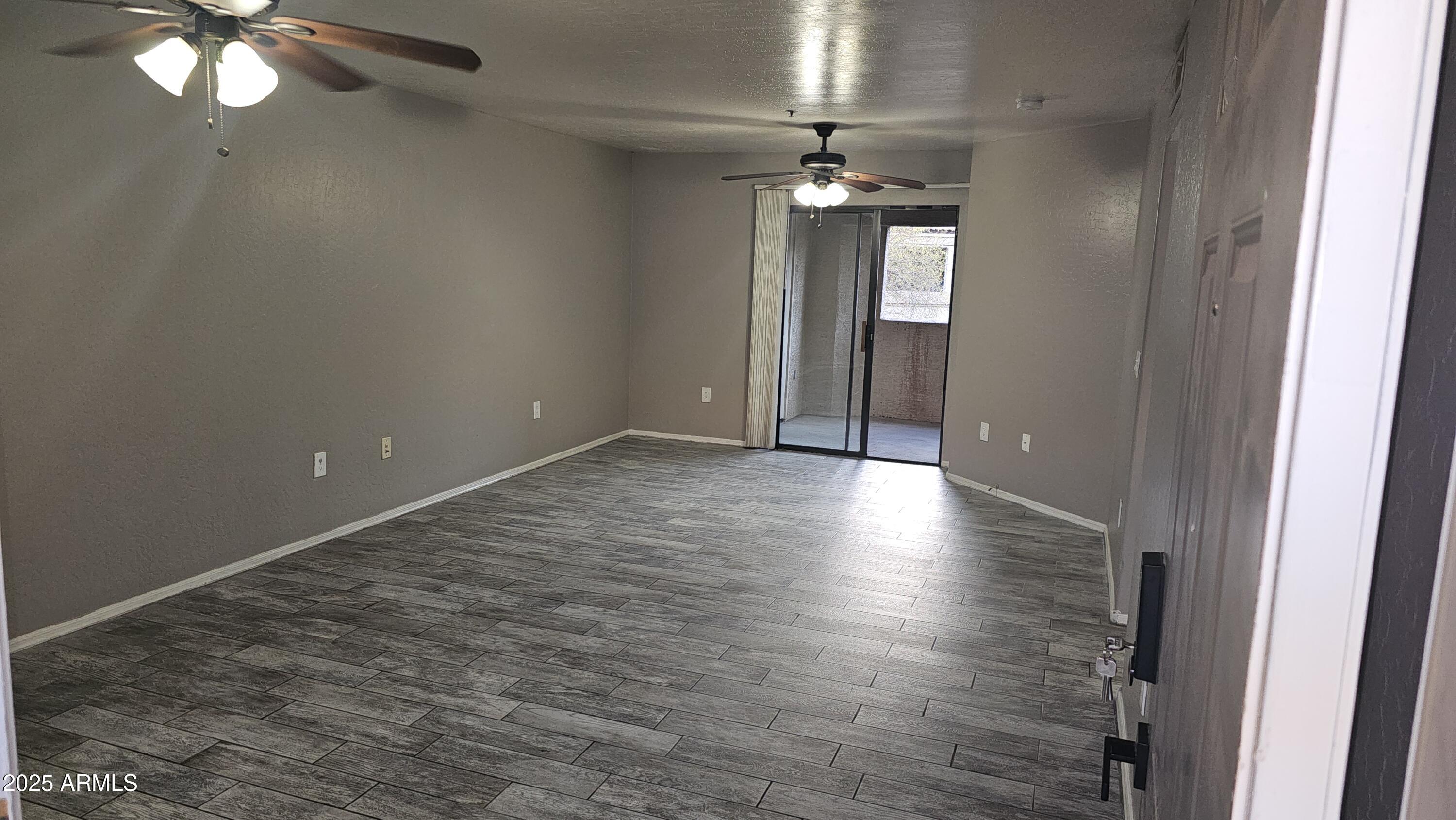 1287 North Alma School Road, Unit 262 Chandler, AZ 85224 - Photo 3 of 19 a view of an empty room with wooden floor and chandelier