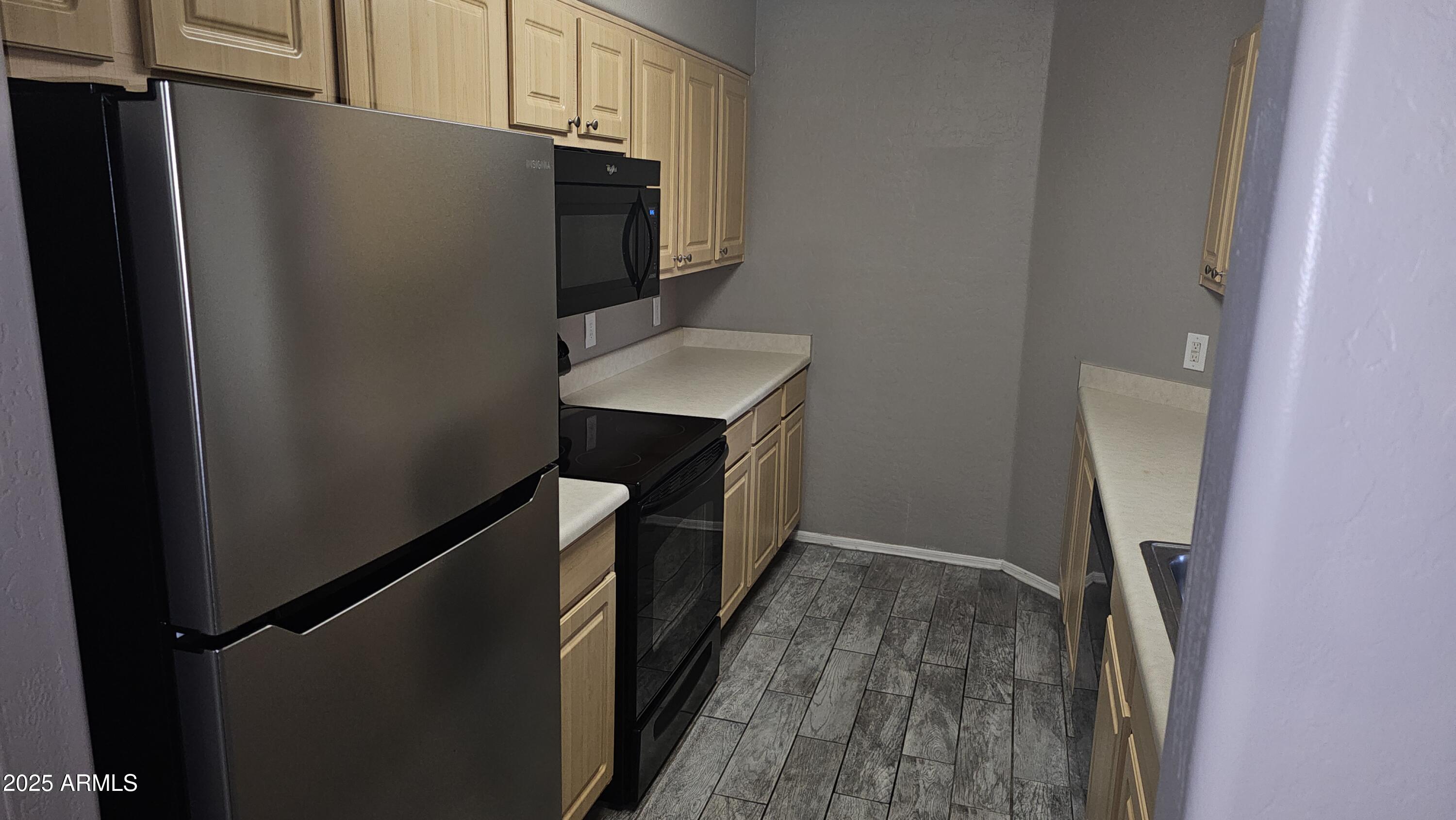 1287 North Alma School Road, Unit 262 Chandler, AZ 85224 - Photo 5 of 19 a kitchen with metallic refrigerator and car parked