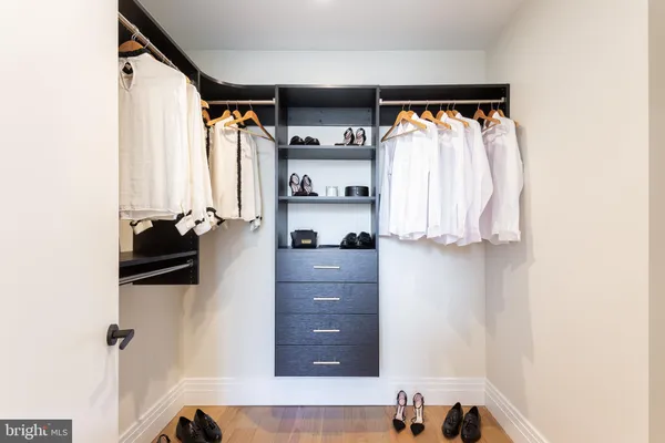 a view of walk in closet with clothes and shoes