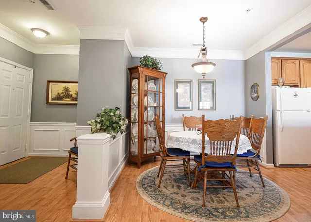 a dining room with furniture a chandelier and wooden floor