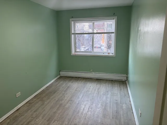 a view of a room with wooden floor and a window
