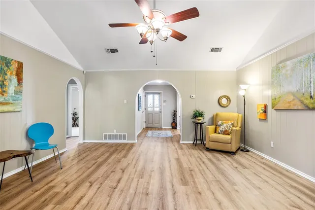 a view of a livingroom with furniture a chandelier fan and wooden floor