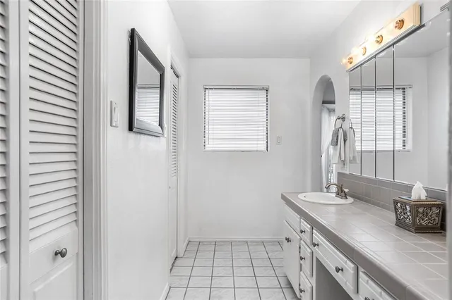 a spacious bathroom with a double vanity sink a mirror and a shower