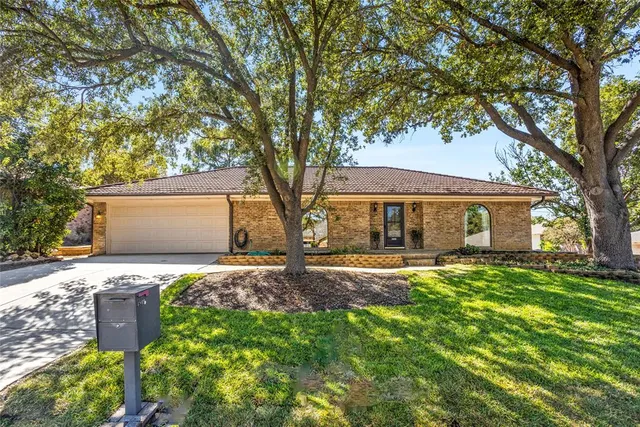 a front view of house with yard and trees