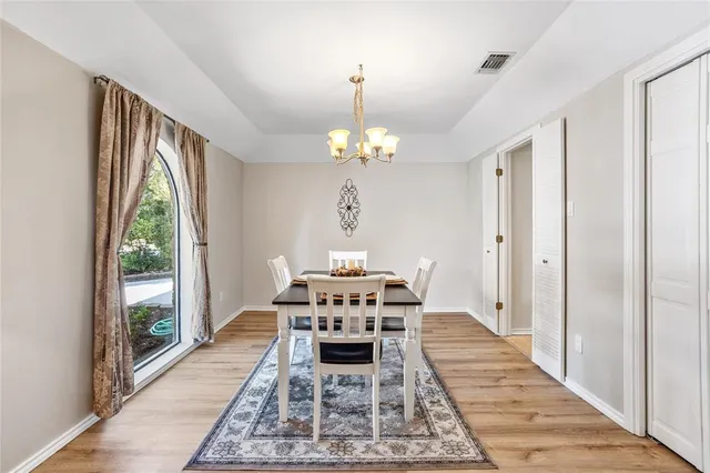 a view of a dining room with furniture a chandelier and wooden floor