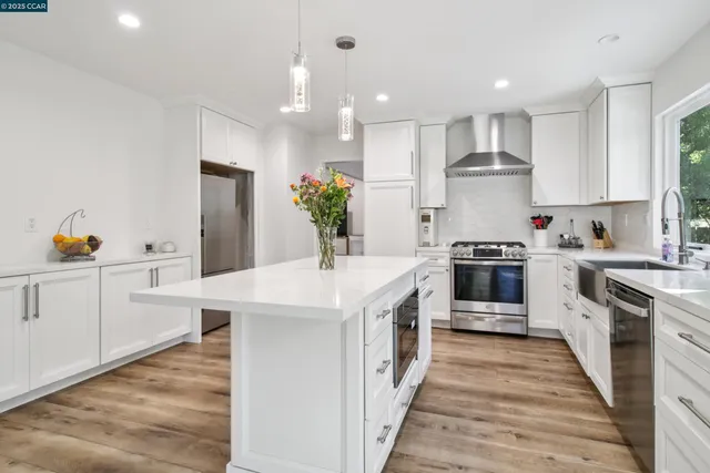 a kitchen with a sink a stove top oven and white cabinets