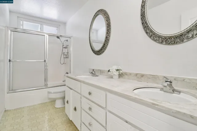 a bathroom with a granite countertop sink mirror vanity and a toilet